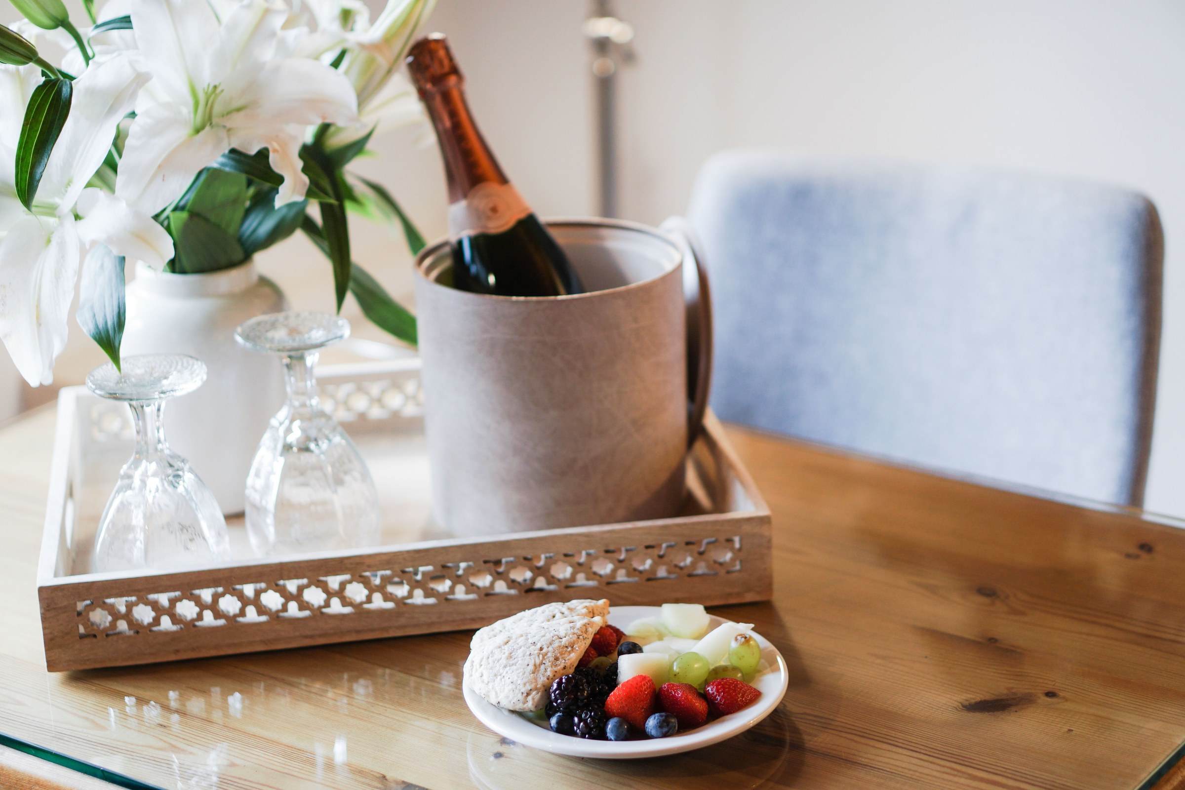 A welcome moment at Maison Aladdin — fresh lilies, chilled rosé, fresh berries, and crystal glasses on a wooden tray.